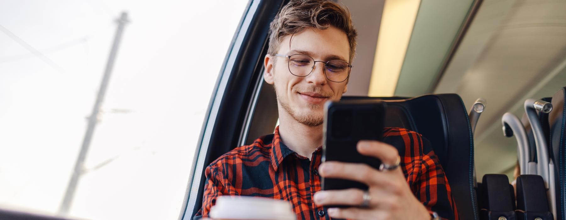 a man holding a cup and a cell phone